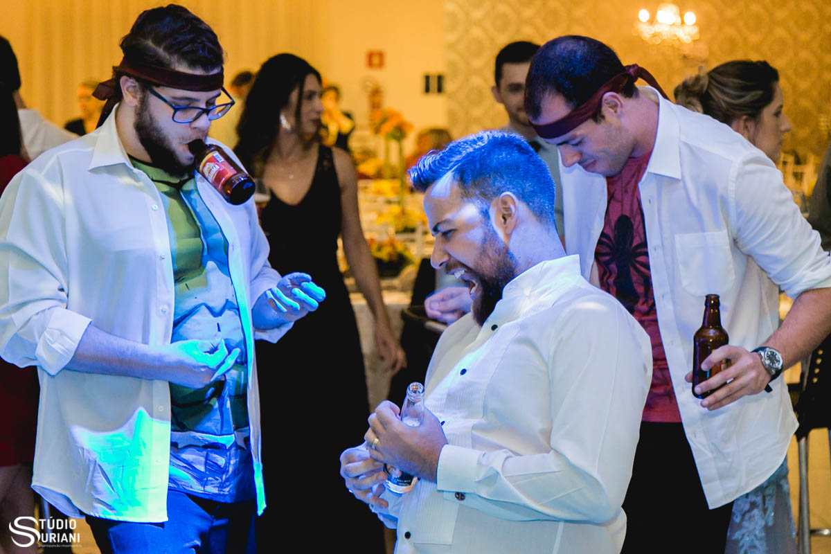 noivo bêbado tocando guitarra com garrada de cerveja com os padrinhos