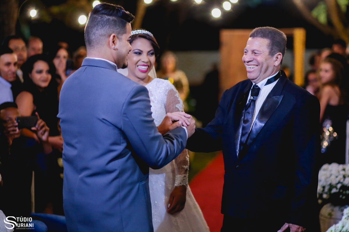aperto de mão apertado entre pai e gero no casamento ao ar livre em uberlandia