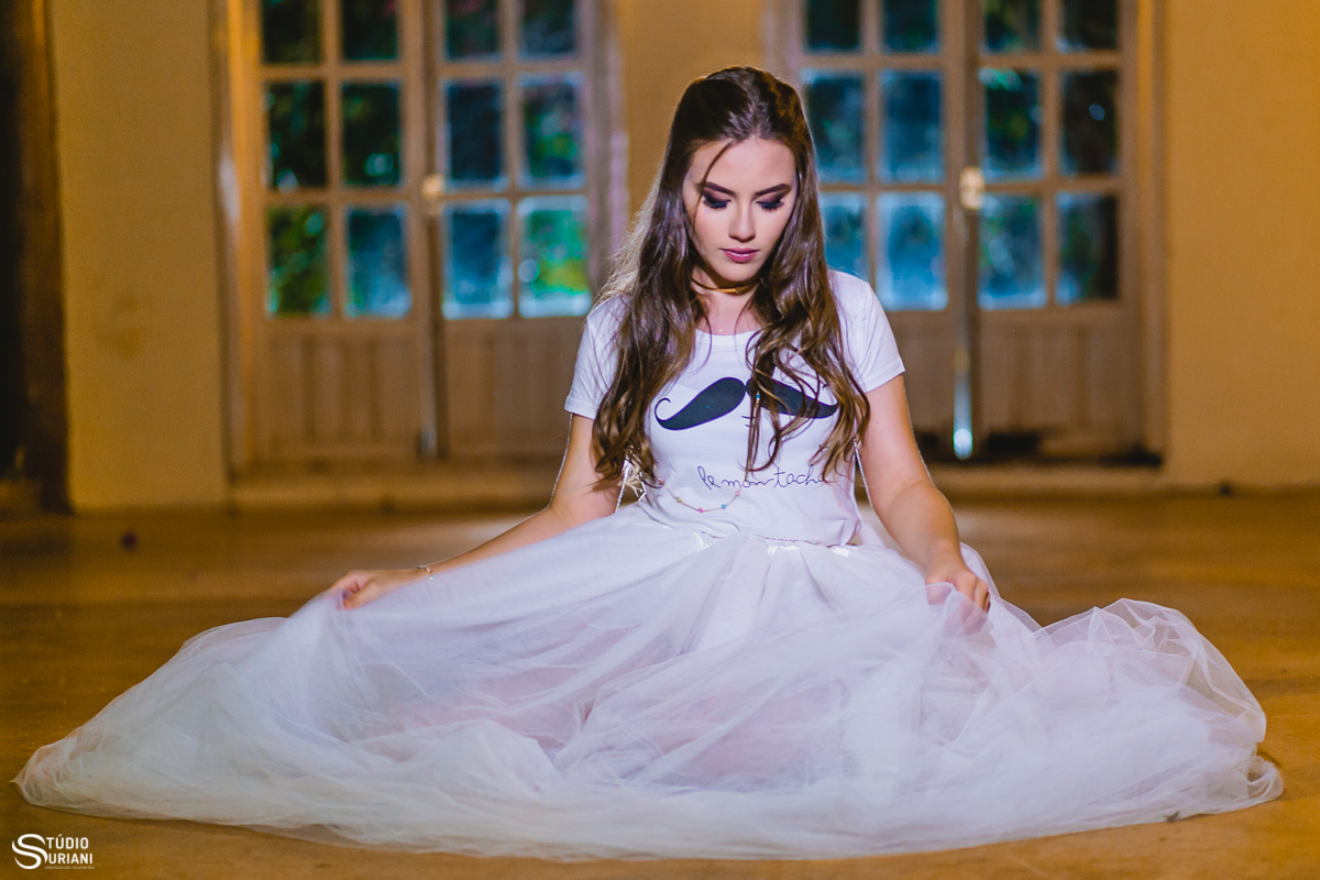 sentada no chão com vestido tule e pensativa.