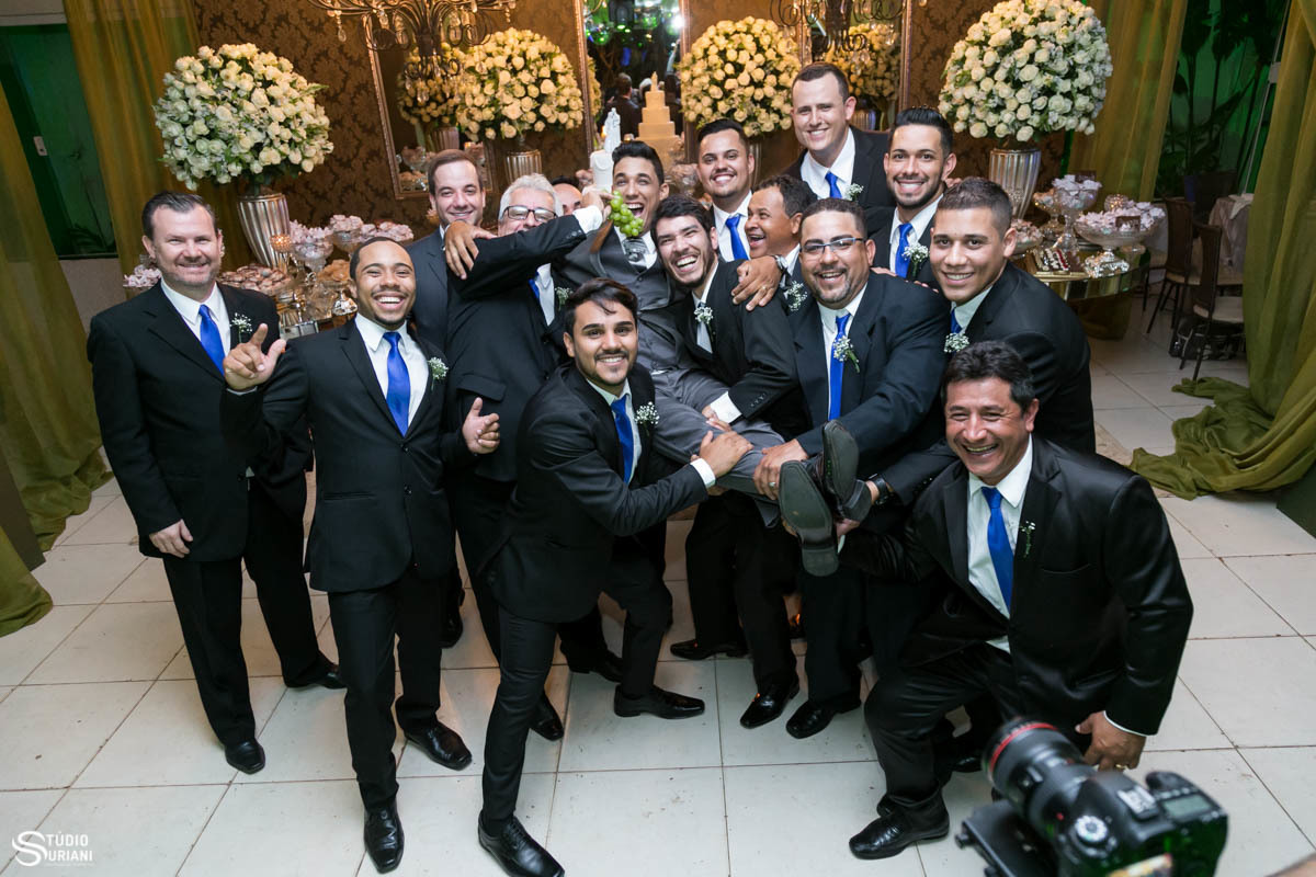 Padrinhos sacaneando o noivo no casamento com linda decoração na mesa do bolo  