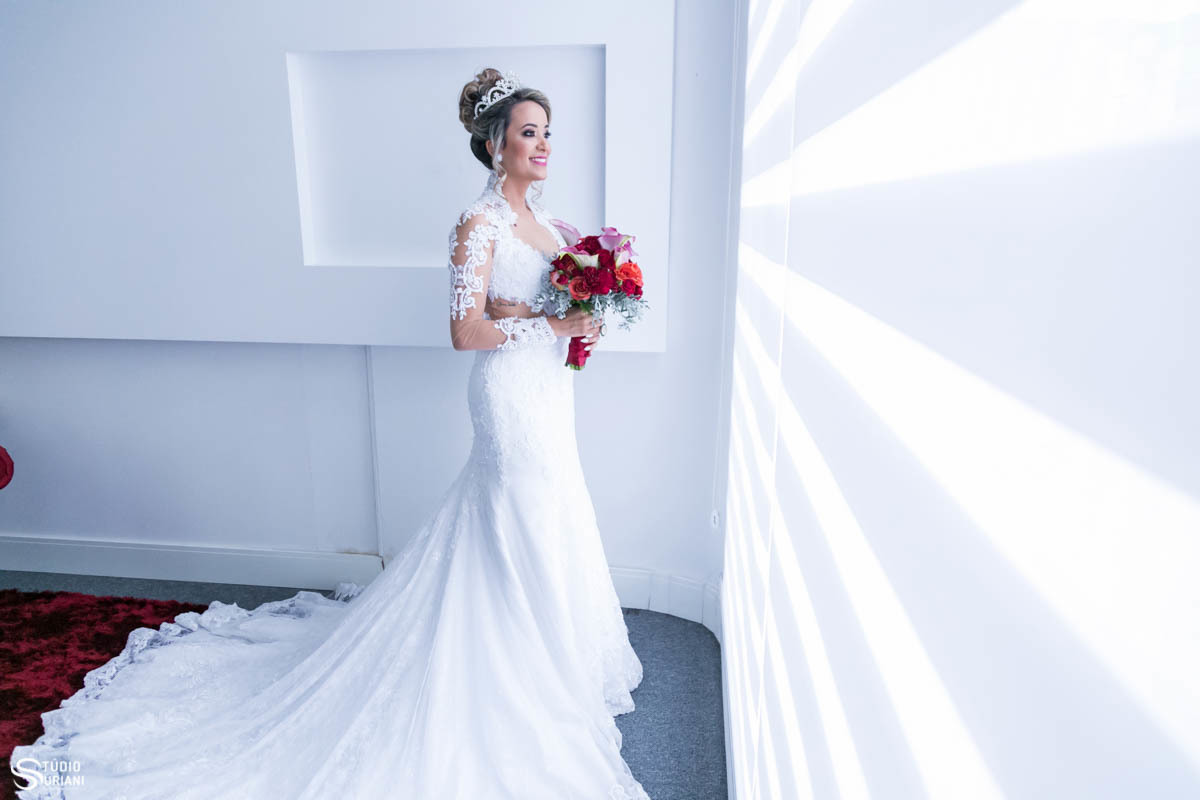 lindo vestido de noiva com braços e pescoço cobertos e lindo buque com flores exóticas 