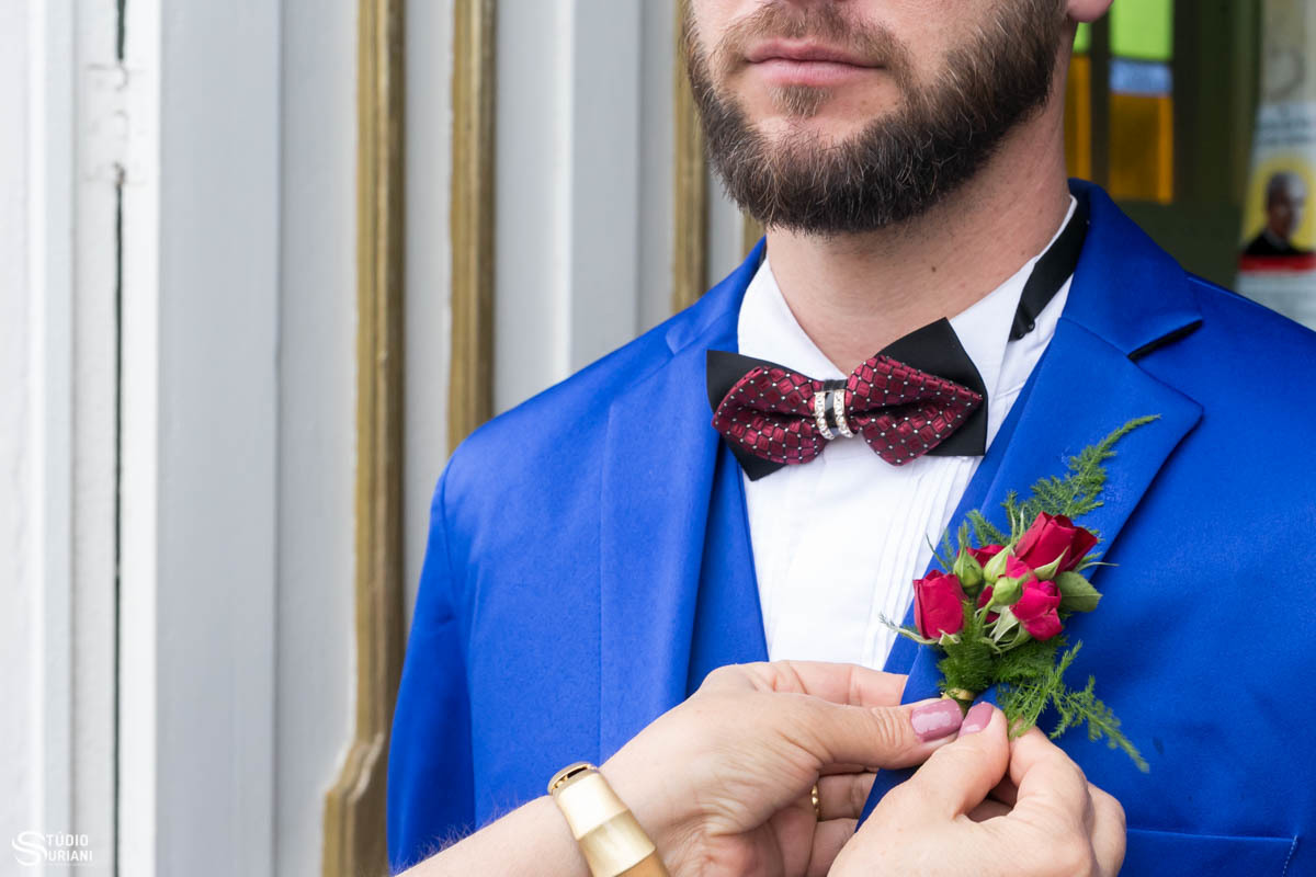 Linda lapela de flores vermelhas, gravata borboleta vermelha e terno azul