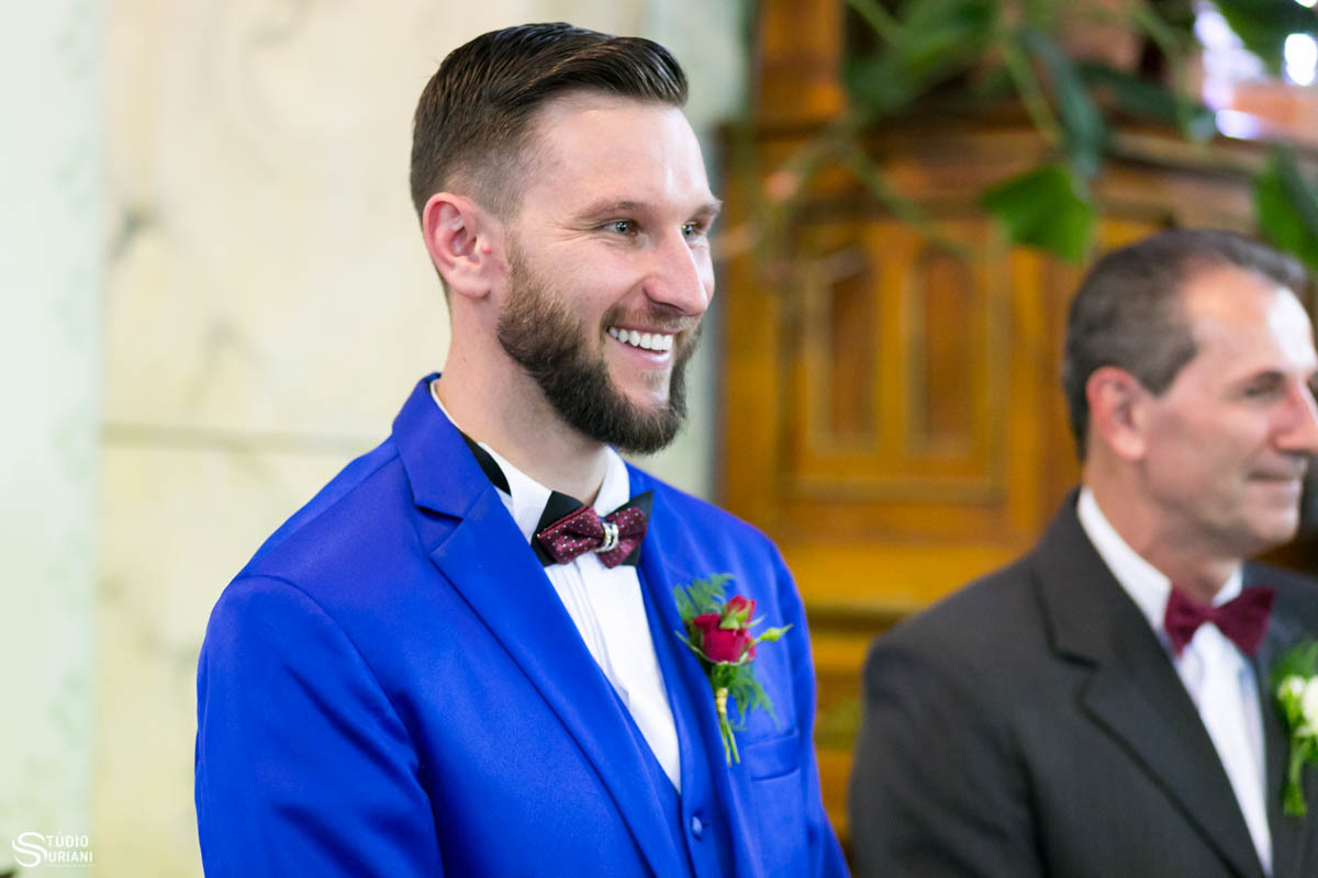 Noivo sorrindo para a noiva na entrada do casamento 