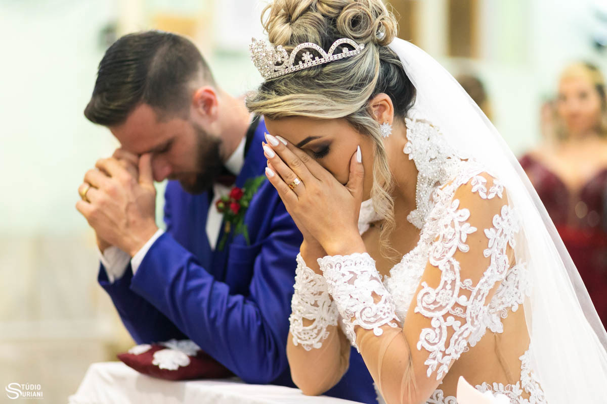 Noivos rezando após receber a Ostia sagrada na benção nupcial  