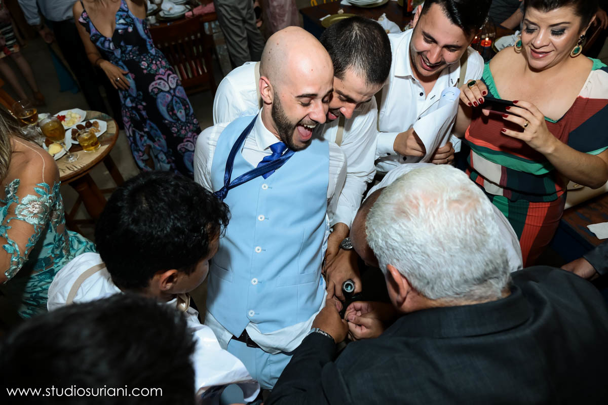 Padrinhos cortando a cueca do noivo 