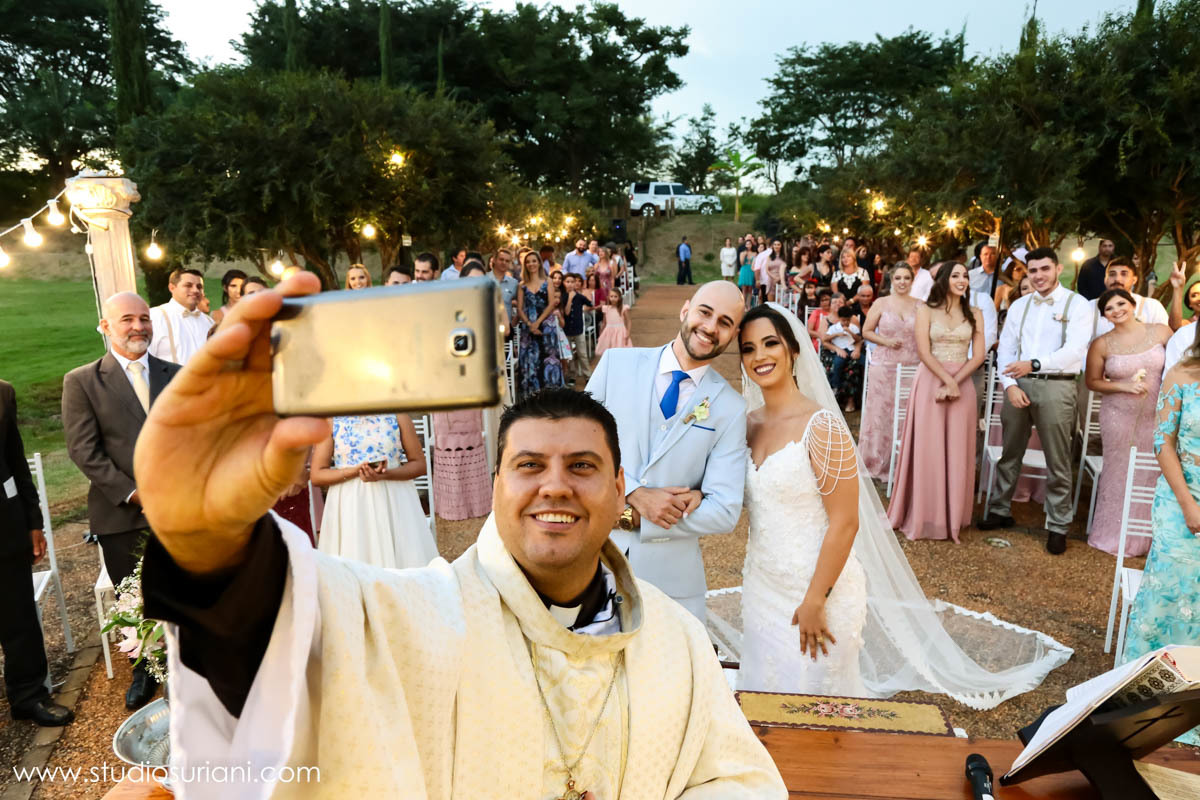 Padre fazendo selfie com os noivos no casamento