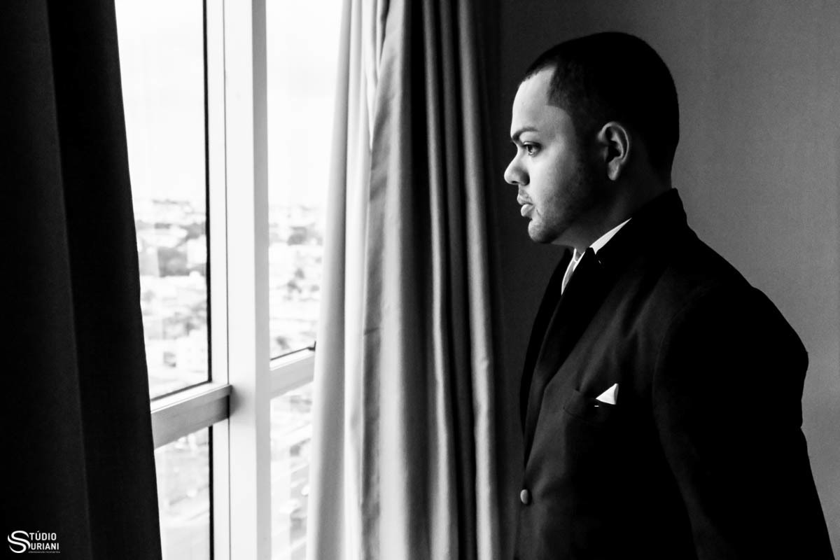 Noivo pensativo na janela do quarto 