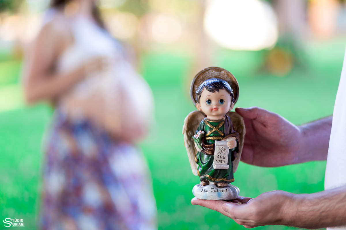 Ensaio de gestante usando o santinho do anjo Gabriel que é o santo do bebê 