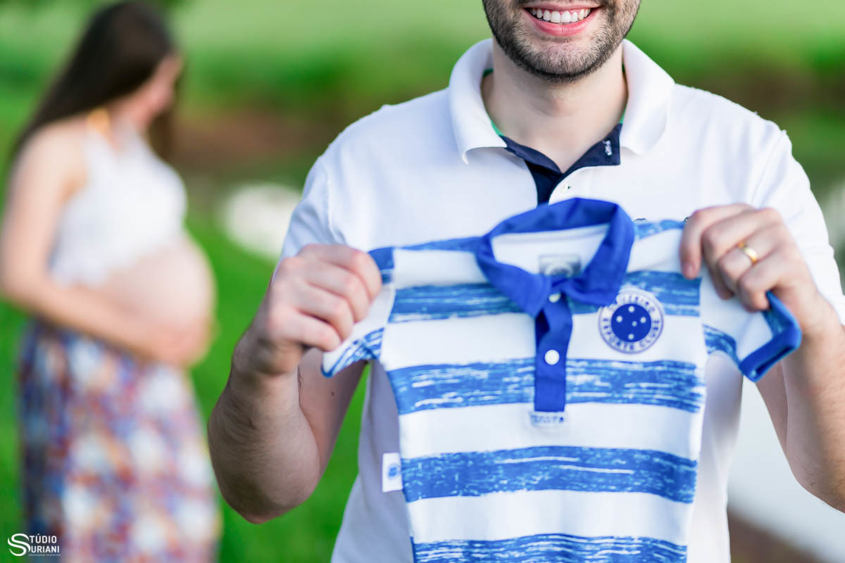 pai sorridente fazendo ensaio fotográfico da gestação da sua esposa 