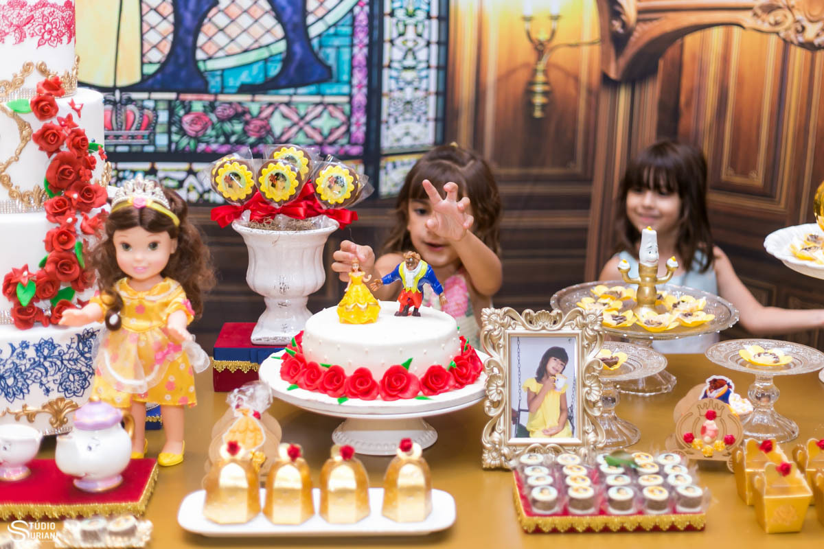 Aniversariante brincando com decoração da mesa de bolo