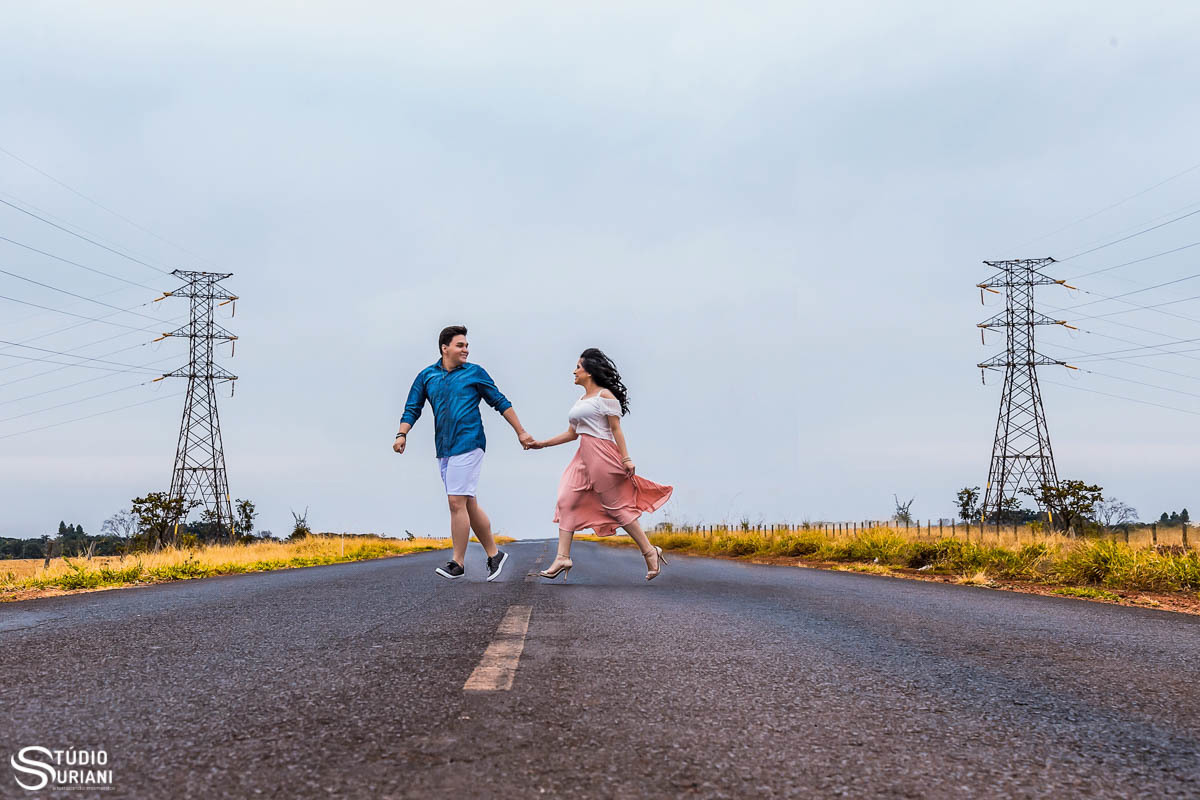 Casal correndo entre duas antenas em ensaio externo em uma estrada de asfalto 