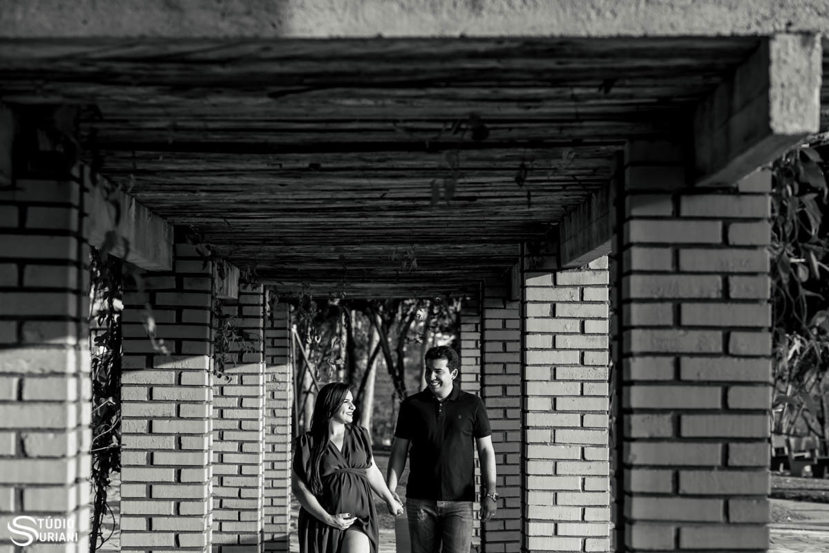 papai e mamãe gestante caminhando de mãos dadas no gazebo no clube Cajubá em Uberlândia 