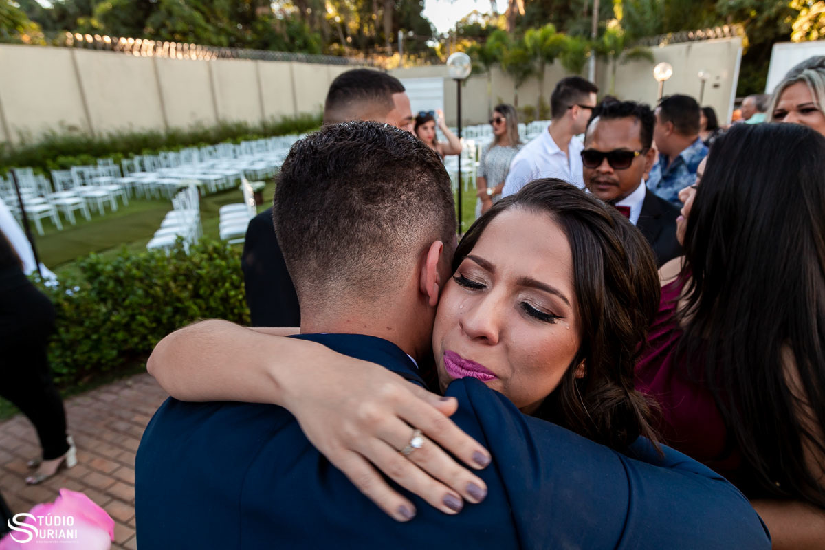 Irmã do noivo chorando ao abraçar o irmão após o casamento