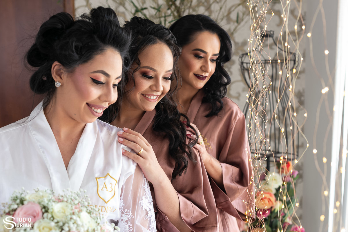 Noiva fazendo fotos com irmã e melhor amiga no salão antes do casamento em chácara 