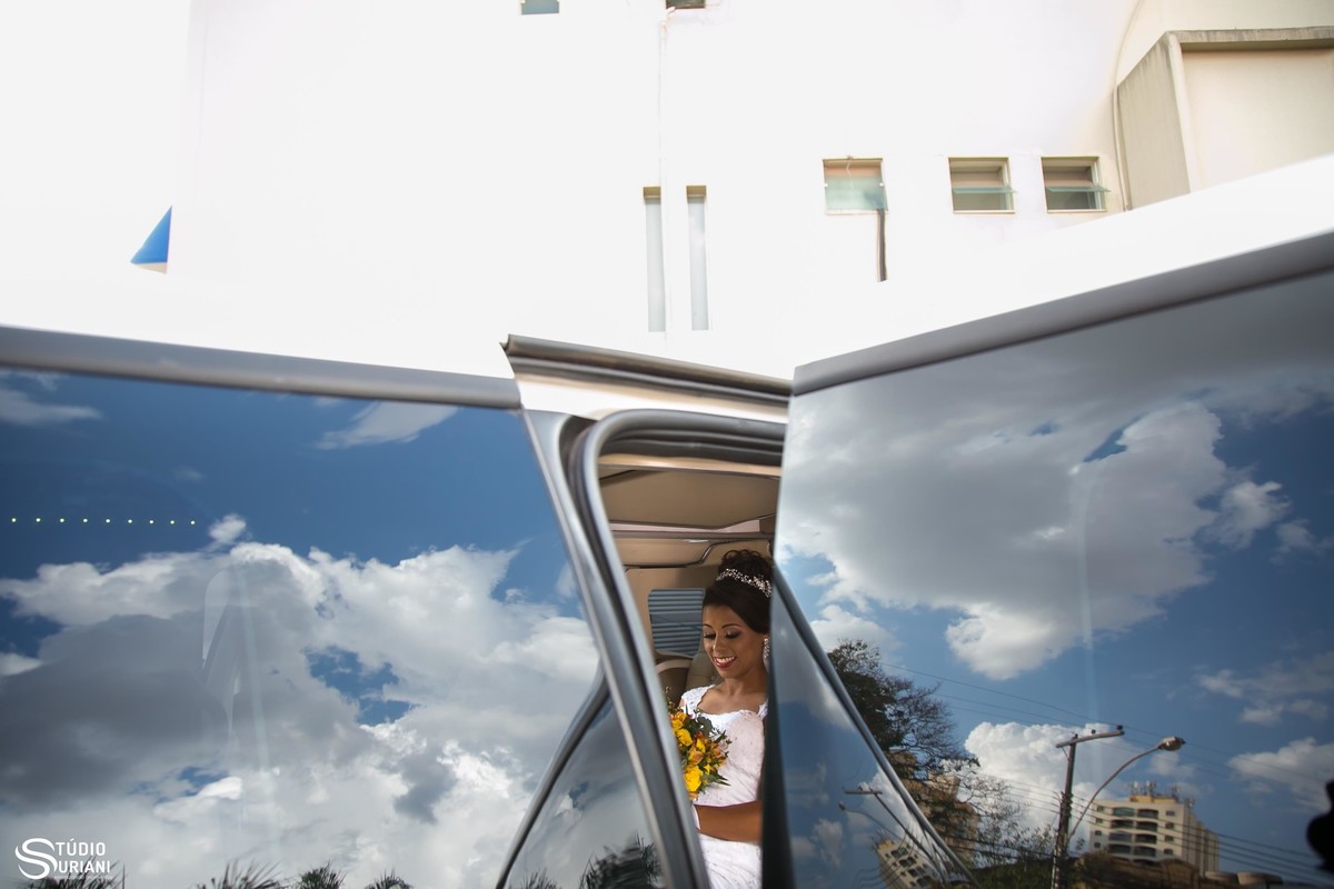 noiva da limozine antes do casamento com buque amarelo e vestido de noiva
