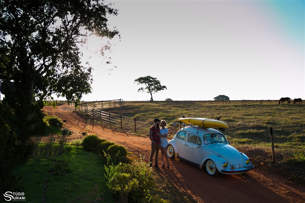 ensaio fotográfico no campo com carro antigo cavalos e estrada de chão