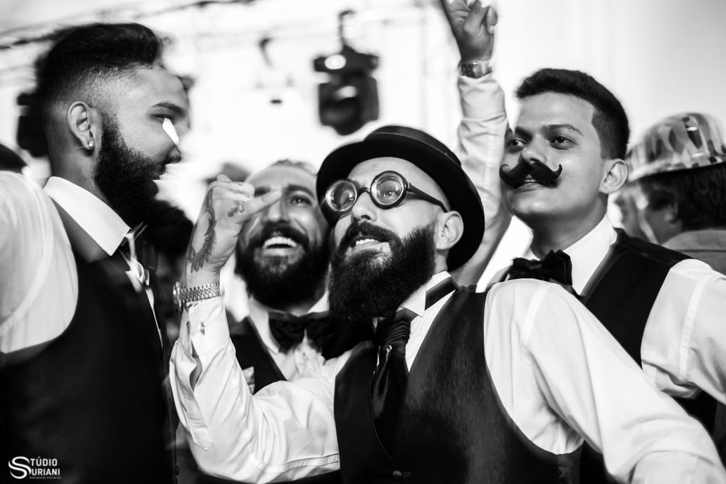 alegria do noivo no dia do casamento se divertido com os amigos com óculos e bigode falço