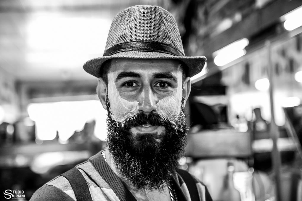 noivo com barba estilo lenhador de uberlandia fazendo making of na barbearia com espima de barbiar no rosto