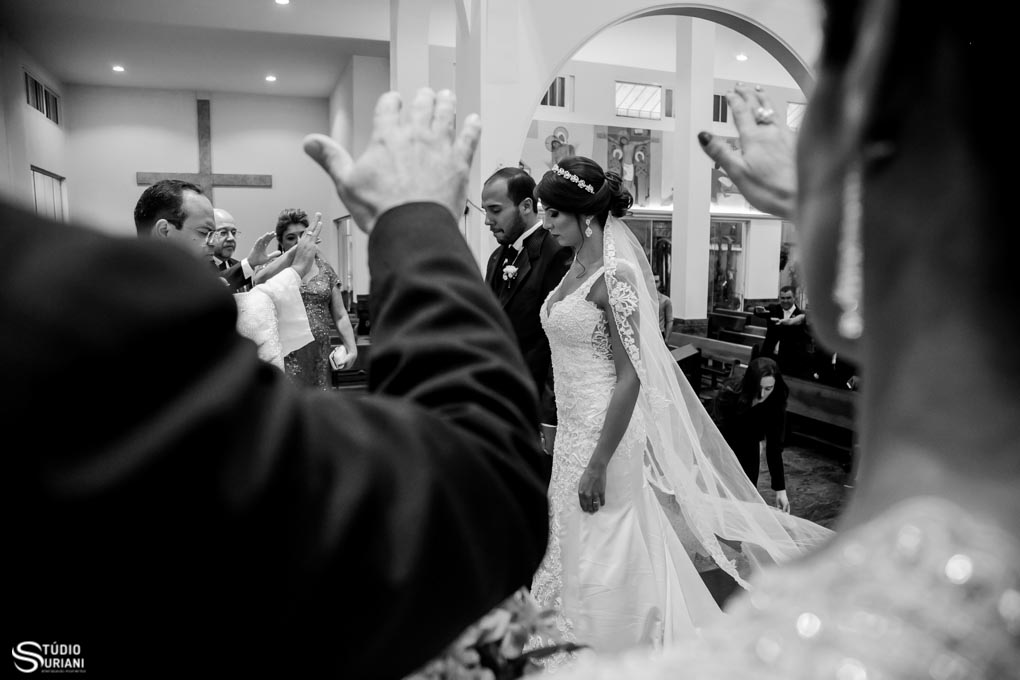 pais abençoando os noivos na cerimonia religiosa com lindo vertido de noiva com vel