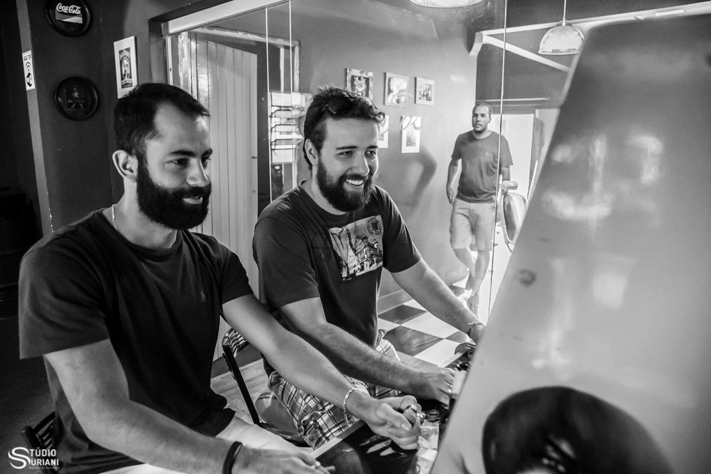 Noivos e padrinhos se divertindo no making of na sala de jogos com sinuca e fliperama na barbearia