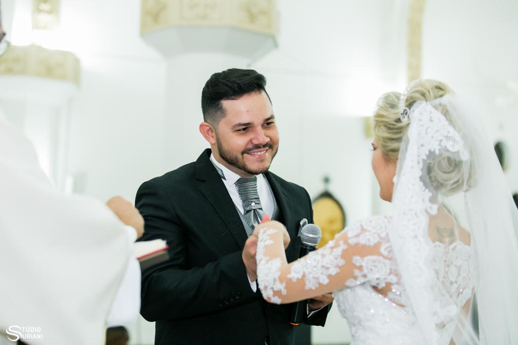 noivo sorrindo para a noiva durante a troca das alinças