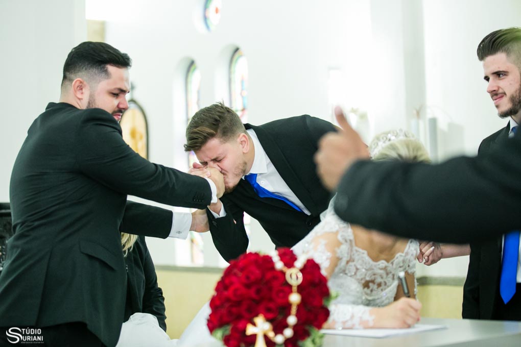 amigo emocionado beijando a mão do noivo no casamento