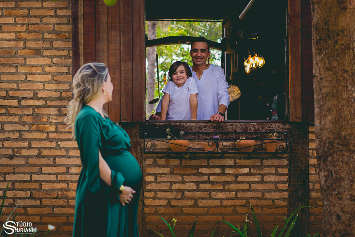 Família na janela e mãe olhando para filho e esposo 