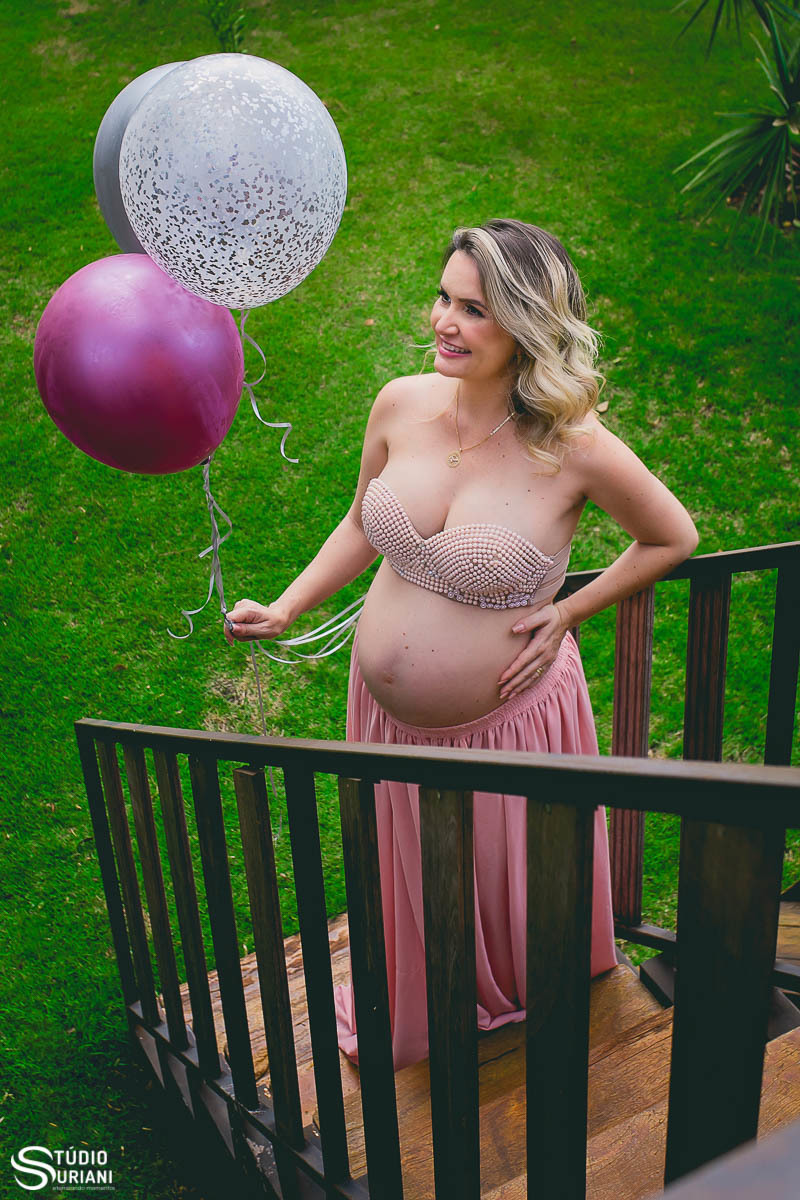 Foto com balão rosa e saia rodada rosa bebê com grama verde 