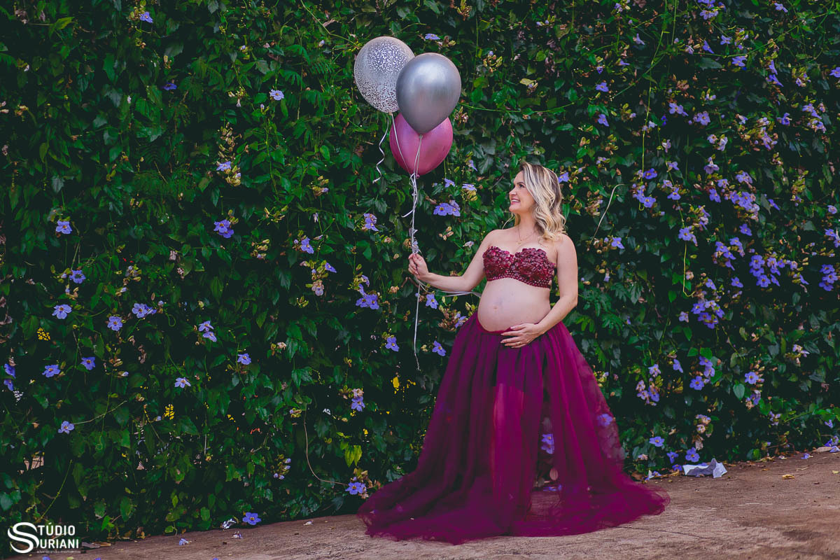 Empresária de Uberlândia Luciana Martins faz fotos com o fotógrafo Rogério Suriani em parede de flores roxas e balões coloridos 