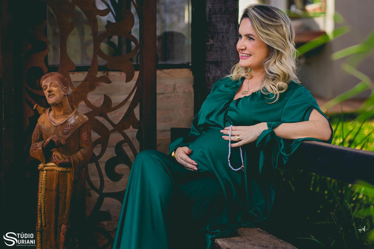 Empresário faz fotos ao lado da imagem de São Francsico de Assis com terço nas mãos