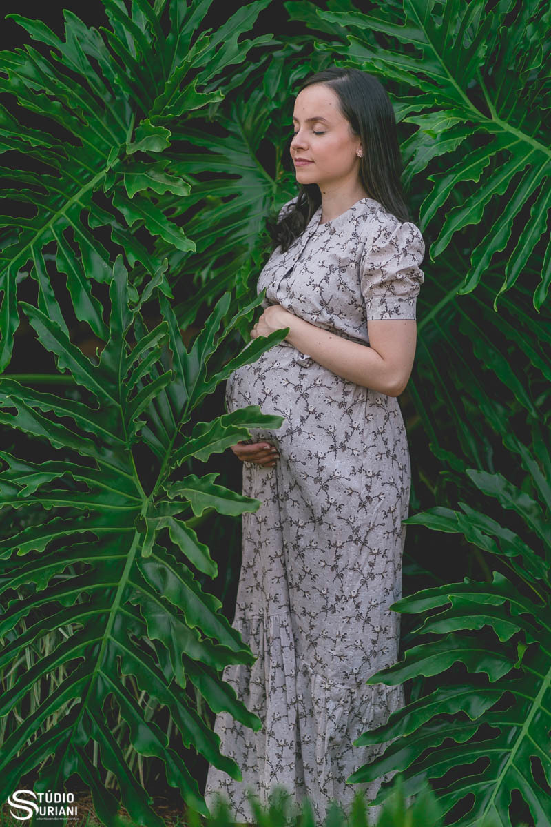 melhores fotógrafos de gestação de Uberlândia com grávida em meio as folhagens verdes de planta aquatica 