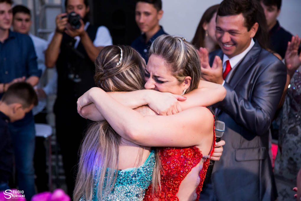 mae emocionada sendo homenagiada pela filha debutante