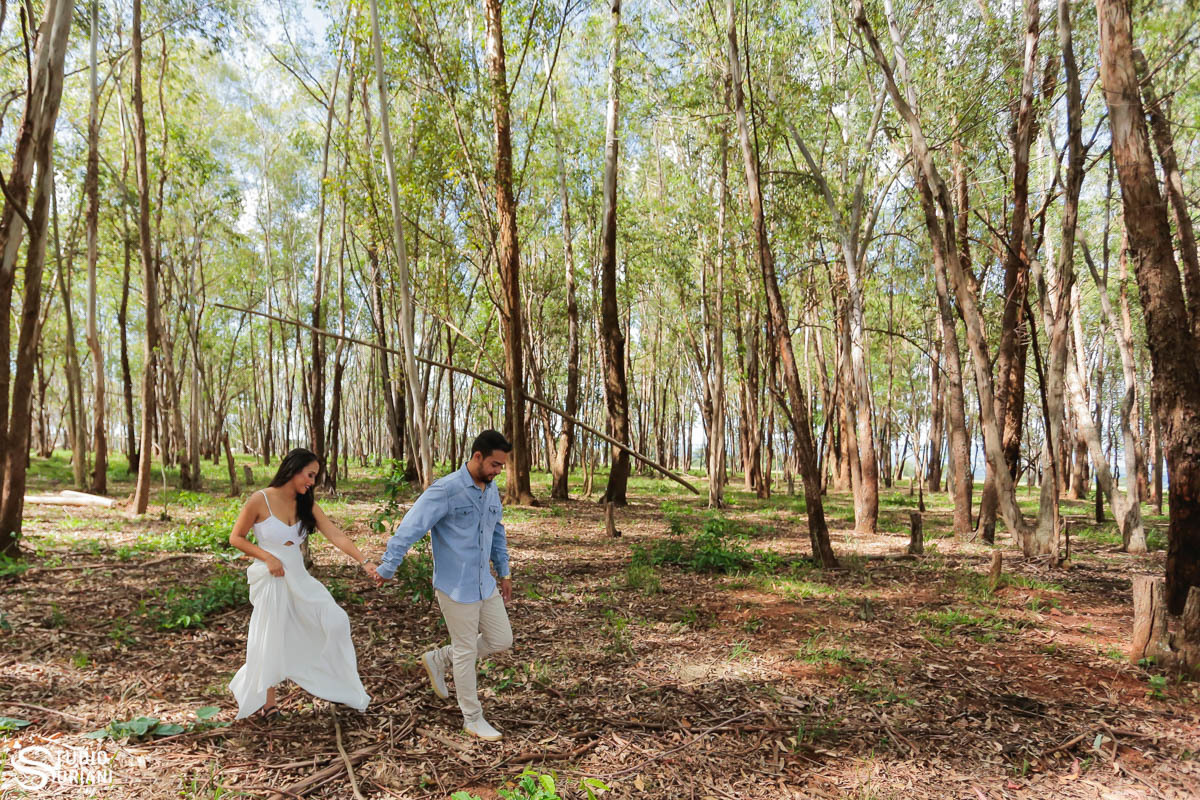 Casal caminhando pela floresta de mãoes dadas