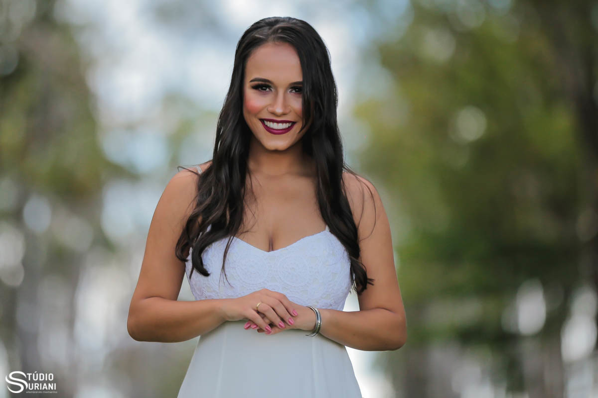 Linda noiva morena olhando a alinça de casamento com vestido branco em ensaio fotográfico com o fotógrafo Rogério Suriani