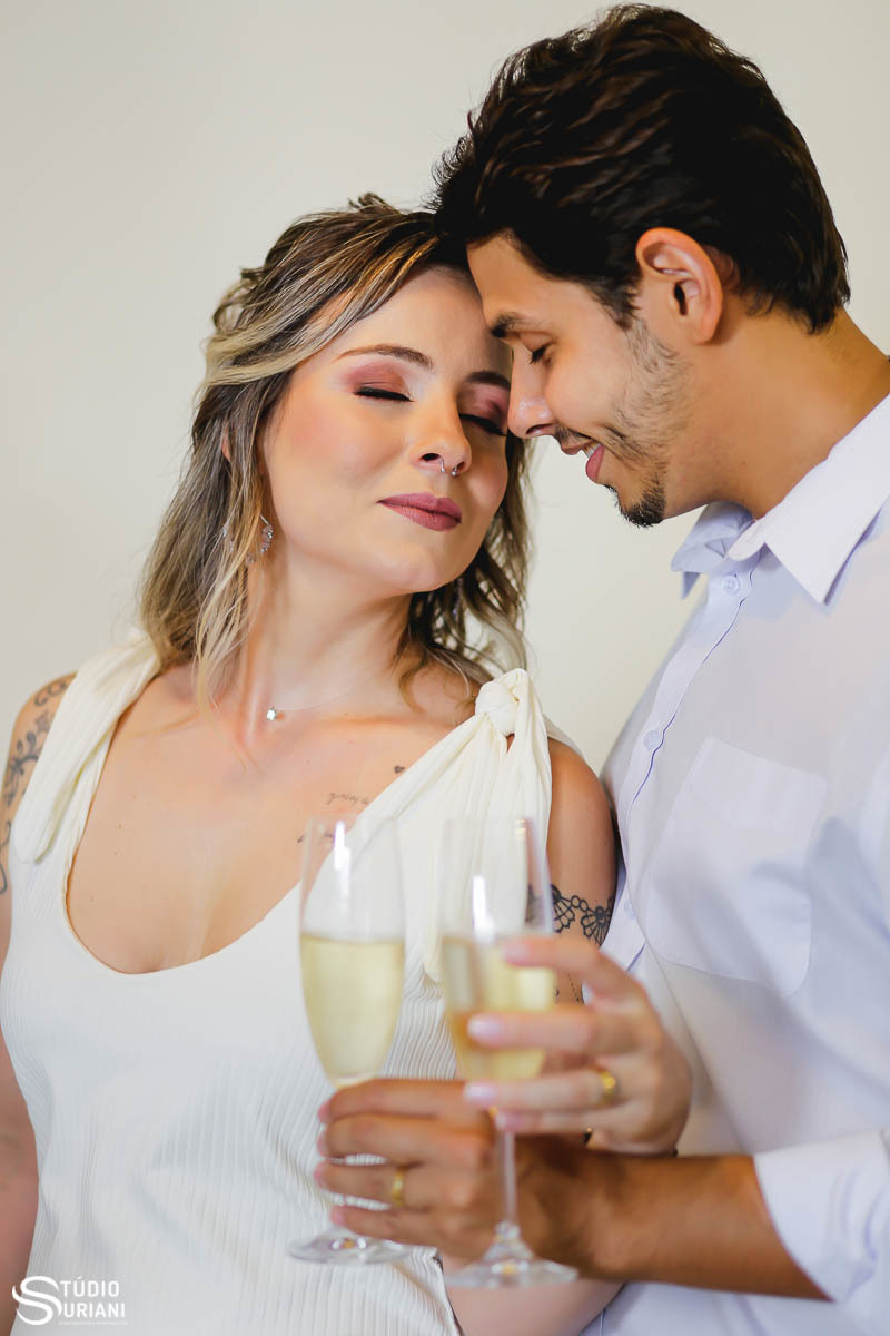 Foto romântica noivos brindando em casa com champanhe e olhos fechados