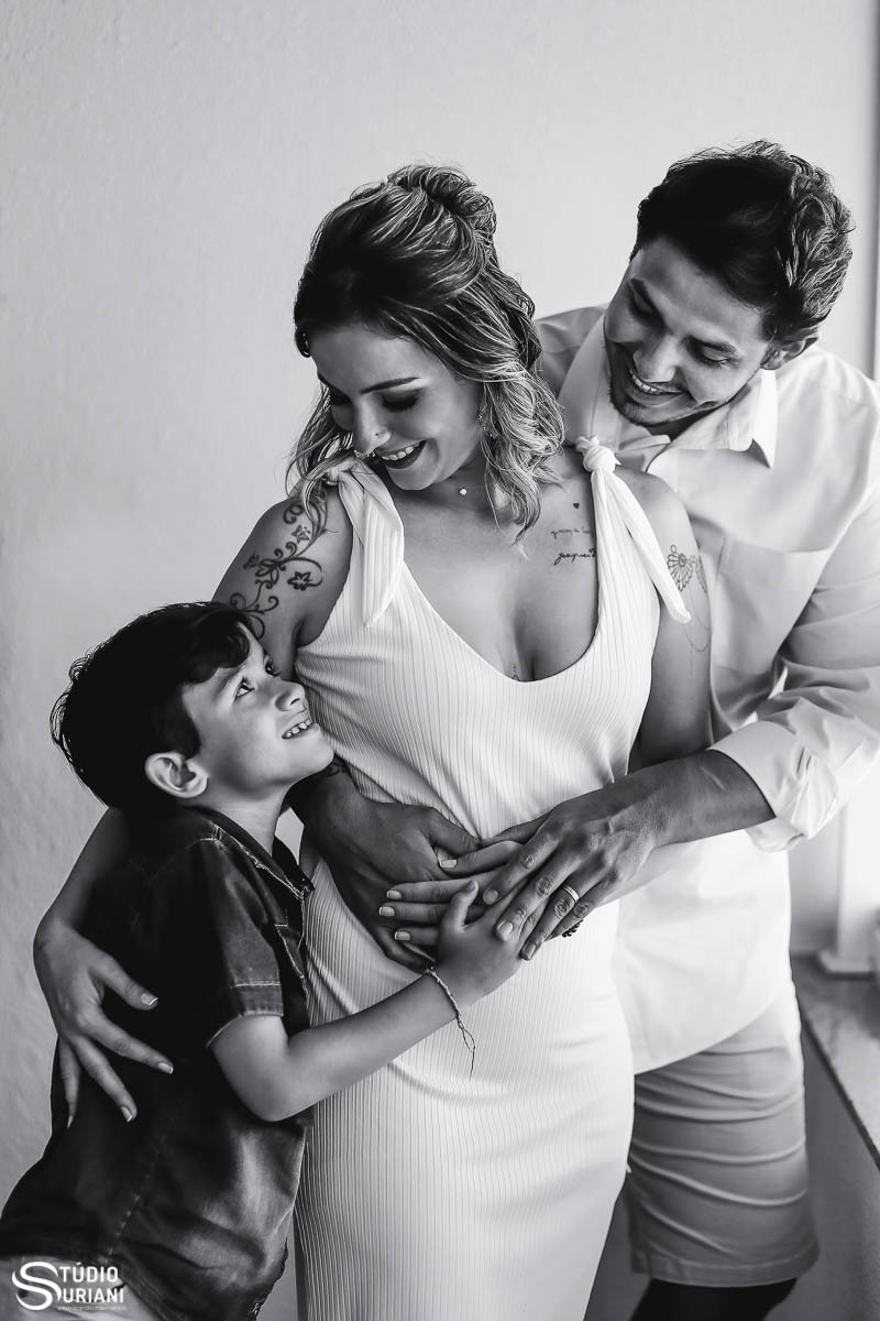 Família pai mãe e filho abraçados em fotografia linda no casamento com ensaio após a cerimônia despojada 