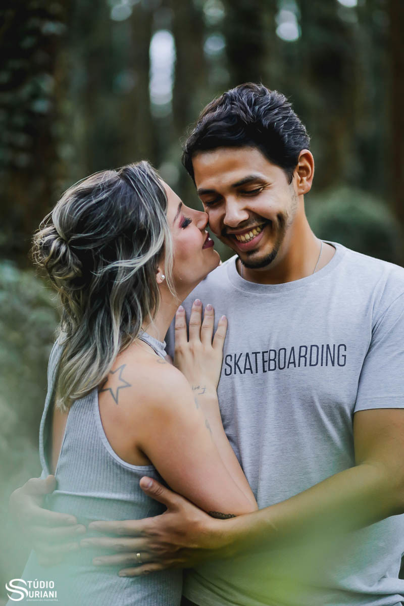 Noiova cheirando o rosto do noivo duante as fotos e noivo caindo na risada 