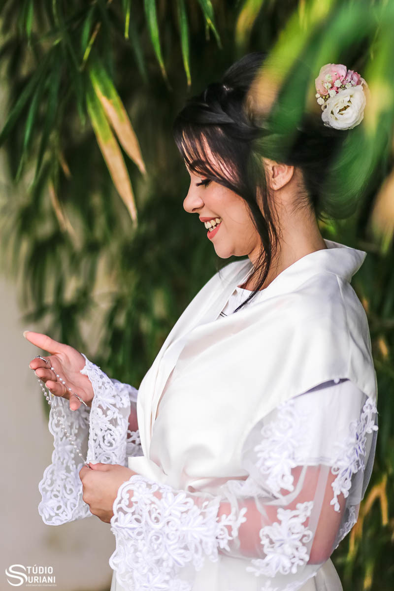 Noiva segurando e olhando para o terço 