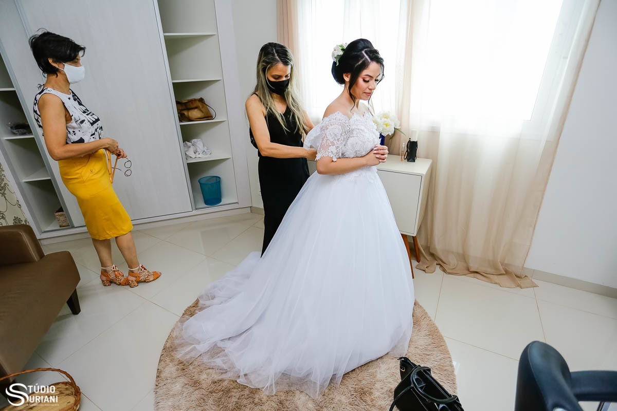 Glória Morais Ateliê colocando o vesido de noiva na noiva 