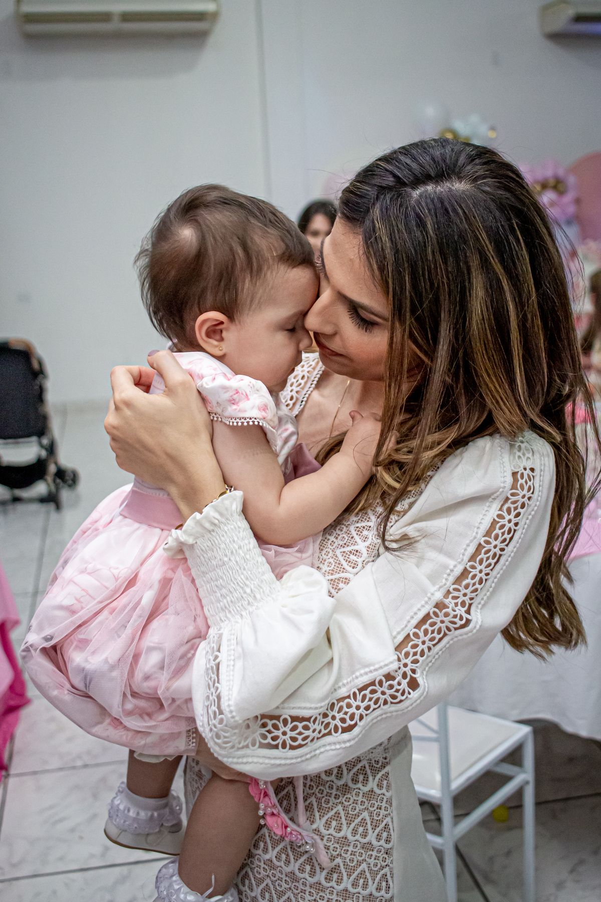 mae brincado com a filha em festa infantil