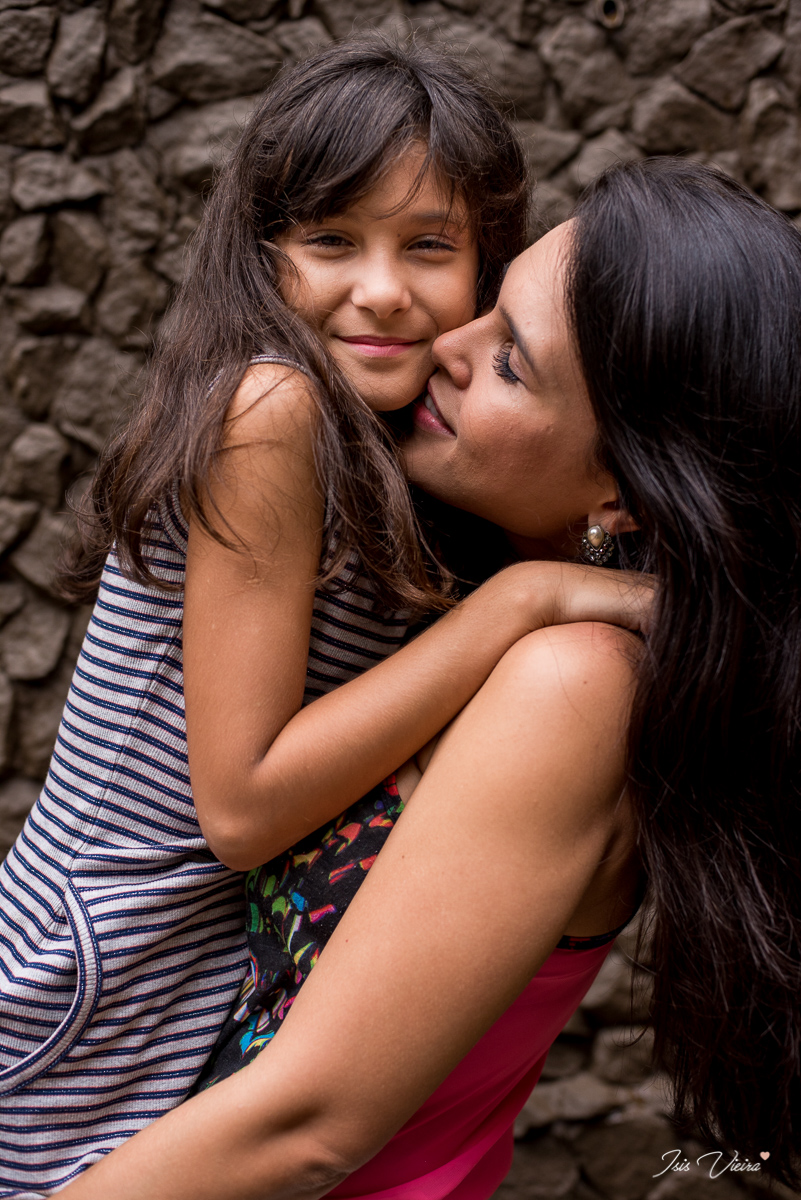 mae carregando a filha em momento de carinho no ensaio fotografico