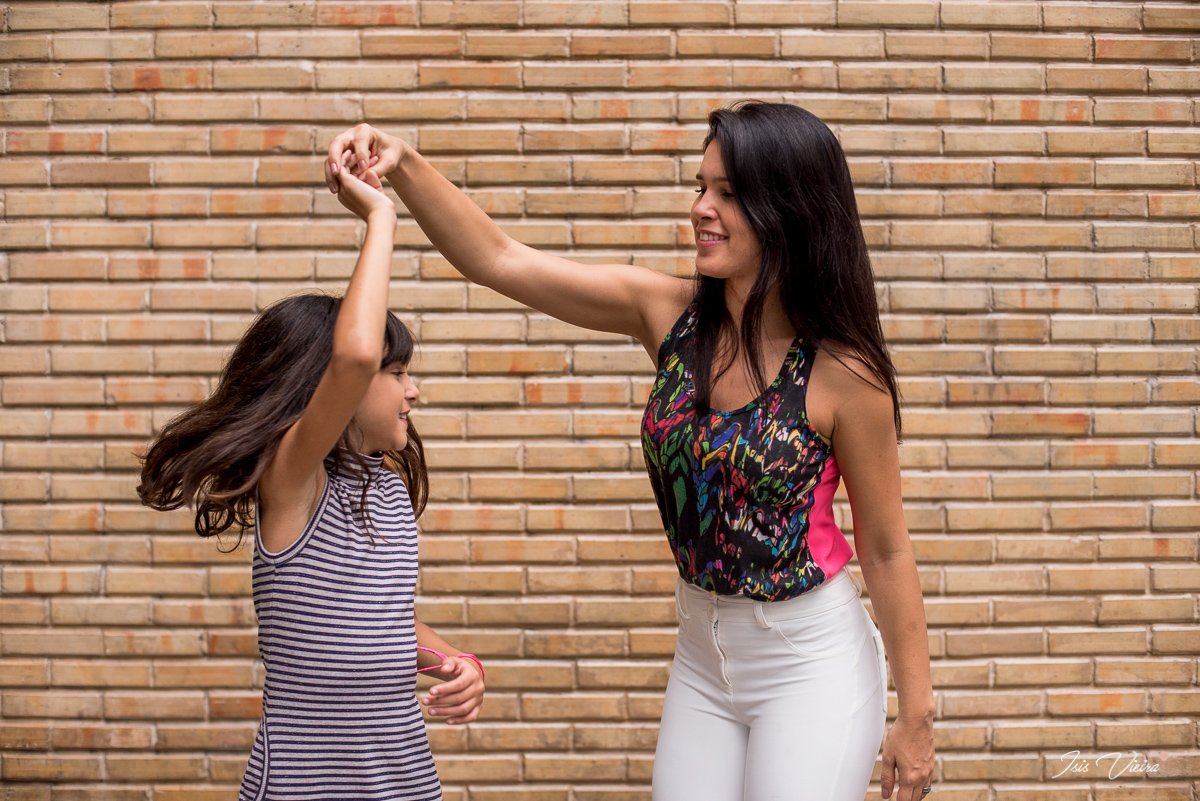 mae e filha dancando felizes em registro fotografico feito por isis vieira fotografia