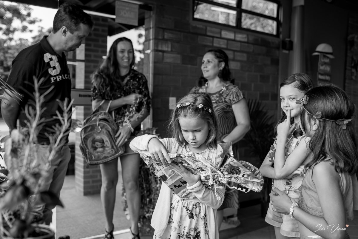 amigas da aniversariante abrindo os presentes de aniversario na festa infantil realizada em florianopolis com registro de isis vieira fotografa de festas infantis e familia