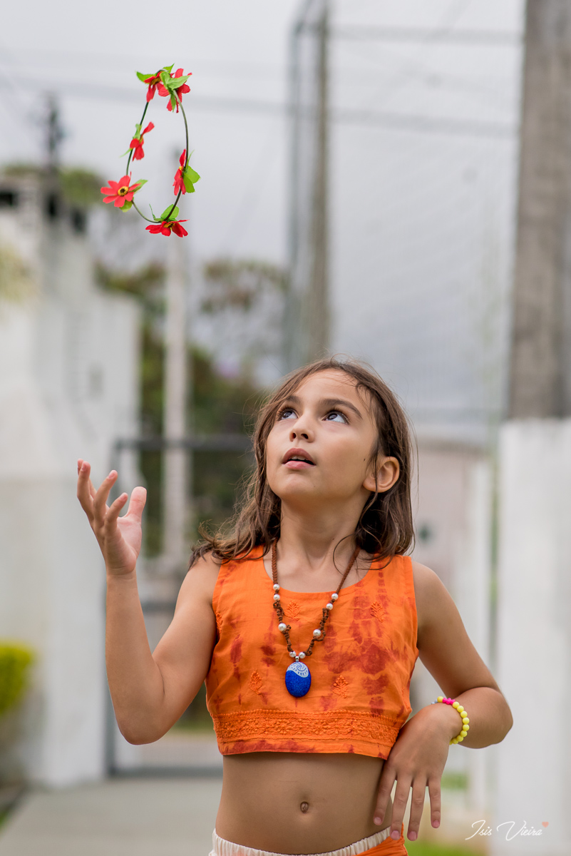 a aniversariante brincando com sua coroa de flores na sua festa de aniversario infantil realizada no itacorubi em florianopolis