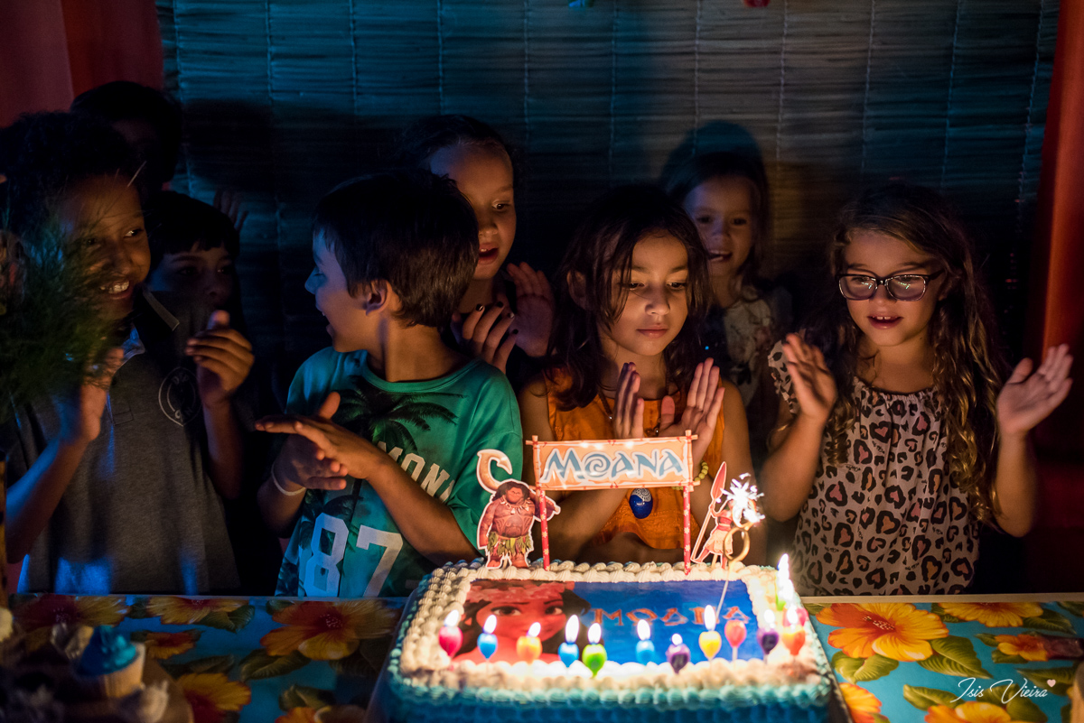 a aniversariante e seus amigos reunidos na mesa de doces e bolo infantil para cantar parabens na sua festa infantil realizada em florianopolis