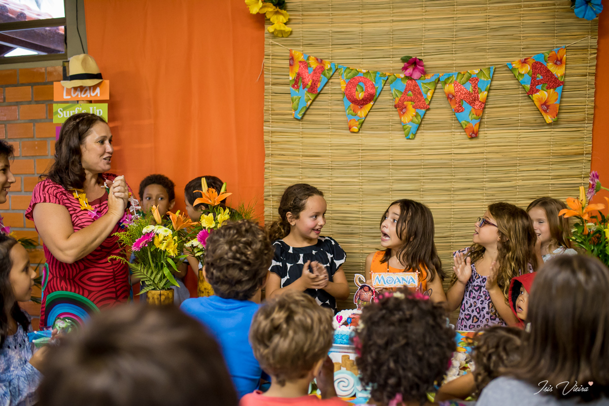 a aniversariante sua mãe e amigas ao redor da linda mesa de doces com decoração infantil do filme da disney moana na sua festa de aniversario infantil