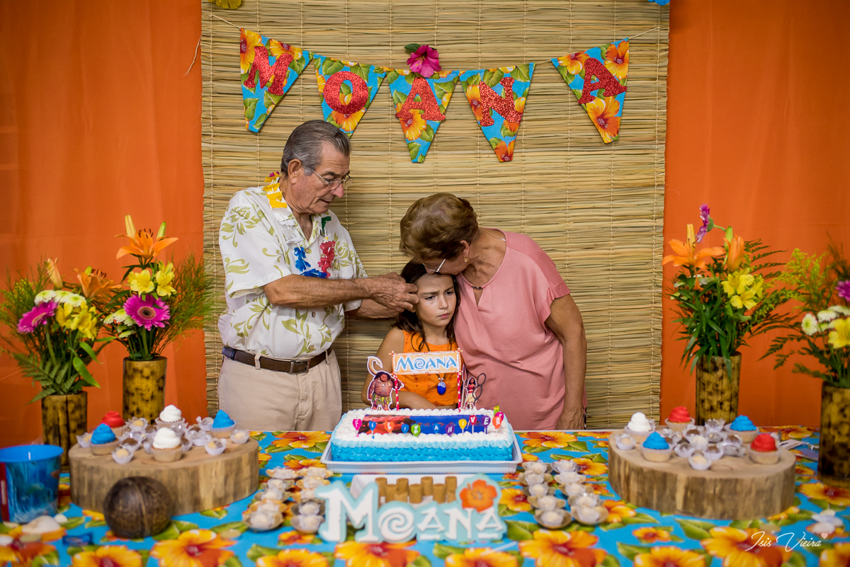 a aniversariante recebendo beijos e carinhos de seus avós logo após os parabéns de sua festa de aniversario infantil em florianopolis