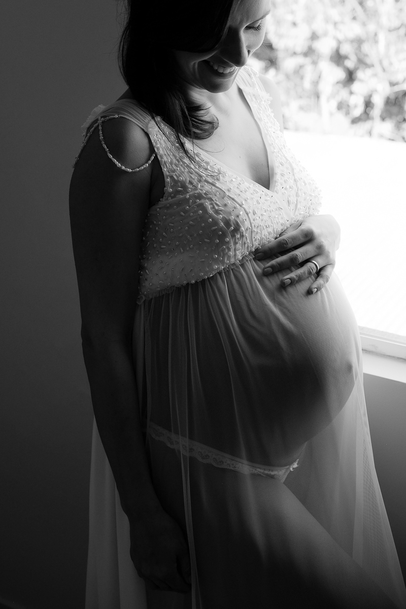 registro da fotografa de familias e gestantes isis vieira da linda gravida flavia em momento especial da sua gravidez onde ela posa para retrato em preto e branco com o foco na sua barriga de 8 meses de gravidez