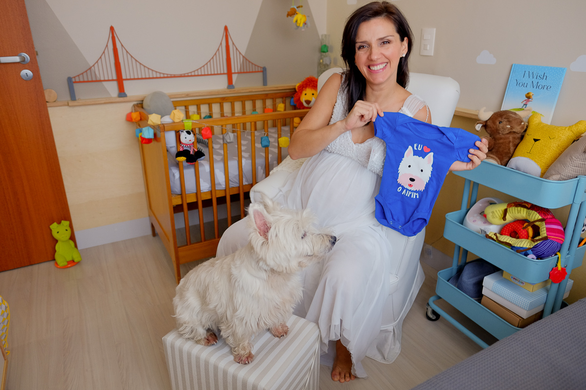 a linda mamae flavia em momento descontraído no quarto de seu futuro bebe com seu cachorro aipim num registro do ensaio de gravida feito pela fotografa isis vieira 