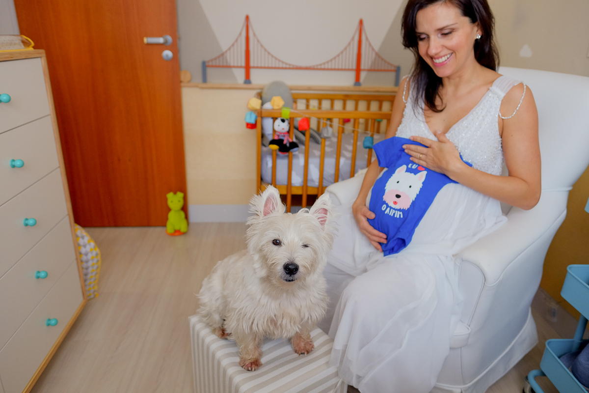 a gestante flavia apoia na sua barriga de gestante um lindo body em homenagem ao seu cachorro aipim que participou do ensaio de grávida realizado na sua casa no bairro do córrego grande em florianopolis sc